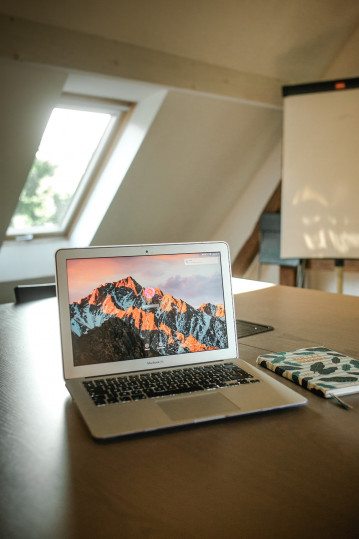 Photo d'un bureau avec un ordinateur portable et un cahier