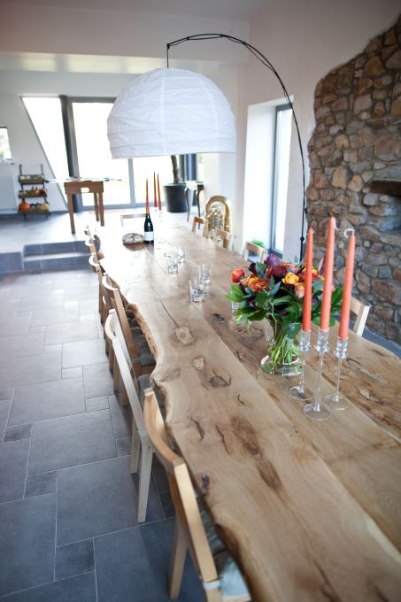 Salle à manger avec grande table en bois brut